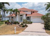 Two-story waterfront home with tile roof and landscaped yard at 1060 San Mateo Dr, Punta Gorda, FL 33950