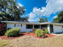 Single-story home with a landscaped yard and attached garage at 18300 Troon Ave, Port Charlotte, FL 33948