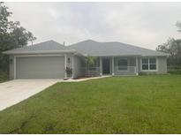Charming single-story home with a well-manicured lawn and an attached two-car garage at 17184 Wintergarden Ave, Port Charlotte, FL 33948