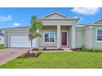 Attractive house exterior with a landscaped lawn and paver driveway at 15512 Greenwood Ave, Port Charlotte, FL 33981