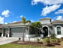 Modern home with three-car garage and landscaping at 13380 Campanile Ct, Venice, FL 34293