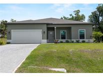 Charming single-story home with well-manicured lawn, neutral paint, and a two-car garage at 2056 Ellery St, Port Charlotte, FL 33952