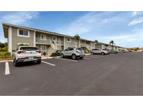 Exterior view of apartment building with parking lot and cars at 3310 Loveland Blvd # 1502, Punta Gorda, FL 33980