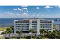 Multi-story waterfront condo building with parking and lush landscaping on a clear, sunny day at 1500 Park Beach Cir # 3C, Punta Gorda, FL 33950