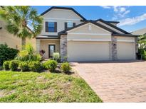 Two-story house with beige siding and three-car garage at 4028 River Bank Way, Punta Gorda, FL 33980