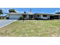 Ranch-style home with white exterior and landscaping at 1629 Birchcrest Blvd, Port Charlotte, FL 33952