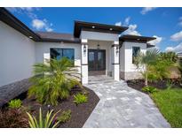 Modern home exterior with double doors and landscaping at 11 Pinehurst Ct, Rotonda West, FL 33947