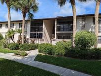 Two-story building exterior with landscaping and walkway at 1515 Forrest Nelson Blvd # E106, Port Charlotte, FL 33952