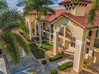 Exterior view of two story building with Spanish tile roof and landscaping at 7196 N Plum Tree # 313, Punta Gorda, FL 33955