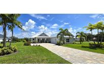 House exterior, showcasing a white two-story home with a paved driveway at 28992 Gin Ln, Punta Gorda, FL 33982