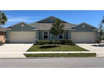 Charming home featuring a well-maintained lawn, a two-car garage, and attractive landscaping at 7168 W Lenox Cir, Punta Gorda, FL 33950