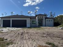 Two-story house with dark brown garage doors and a modern design at 212 Fairway Rd, Rotonda West, FL 33947