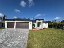 Beautiful one-story home featuring a three-car garage and well-manicured lawn and a paved driveway at 212 Fairway Rd, Rotonda West, FL 33947