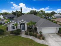 Beautiful single-story home featuring a well-manicured lawn and mature landscaping at 515 Allworthy St, Port Charlotte, FL 33954