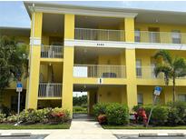 Two-story yellow building with balconies and landscaping at 2140 Heron Lake Dr # 204, Punta Gorda, FL 33983