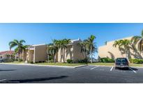 Tan condo building with palm trees and parking at 3251 White Ibis Ct # A4, Punta Gorda, FL 33950