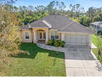 Single-Gathering home with a two-car garage and lush landscaping at 1516 Natrona Dr, North Port, FL 34286