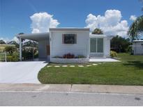 Single-wide manufactured home with carport and well-maintained lawn at 5505 Holiday Park Blvd, North Port, FL 34287