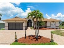 Single-story home with a large driveway, two-car garage, and mature palm trees at 5149 Latham Ter, Port Charlotte, FL 33981