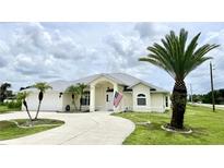 Beautiful single-story home with a large driveway and mature landscaping at 530 Kensington St, Port Charlotte, FL 33954