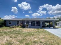 Charming single-story home with a covered carport and screened front porch nestled in a serene and established neighborhood at 1405 Dorchester St, Port Charlotte, FL 33952