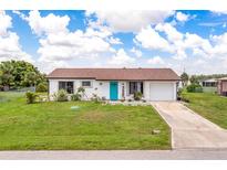 Charming single-story home with a teal door at 5104 Chaves Cir, Port Charlotte, FL 33948