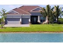 Charming single-story home with a well-manicured lawn and serene water view at 15240 Spanish Point Dr, Port Charlotte, FL 33981