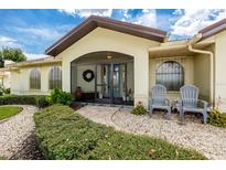 Inviting screened front entrance with a beautifully landscaped walkway and charming seating area at 2807 Via Paloma Dr, Punta Gorda, FL 33950