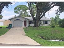 Single story home with a carport, mature landscaping, and a spacious yard at 22378 Laika Ave, Port Charlotte, FL 33952