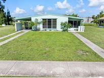 Ranch-style home with carport, spacious lawn and mature landscaping at 3107 Easy St, Port Charlotte, FL 33952