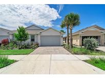 Two-story home with gray garage door and landscaping at 43614 Sparrow Dr, Punta Gorda, FL 33982