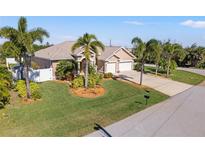 Single-story home with three-car garage and lush landscaping at 14176 Saul Ln, Port Charlotte, FL 33981