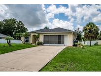 Single-story home with screened-in porch, driveway, and well-maintained lawn at 3721 Monday Ter, North Port, FL 34286