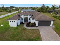 New construction home with a modern design, landscaped yard, and paved driveway at 13493 Los Angeles Ave, Port Charlotte, FL 33981