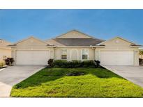Front view of a charming tan house with two garages at 7457 W Lenox Cir, Punta Gorda, FL 33950