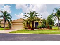 One-story house with tile roof, palm trees and two-car garage at 6913 Talon Bay Dr, North Port, FL 34287