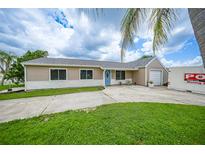 Charming single-story home with a blue door, attached garage, and landscaped yard at 3512 Nekoosa St, North Port, FL 34287