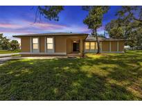 Single story home with light yellow exterior, front yard, and driveway at 791 Haleybury St, Port Charlotte, FL 33948
