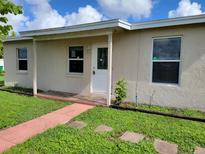 Ranch style home with a covered porch and well-manicured lawn at 21440 Holdern Ave, Port Charlotte, FL 33952