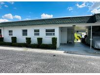 Front view of condo with carport and well manicured hedges at 7739 38Th N Pl, St Petersburg, FL 33709
