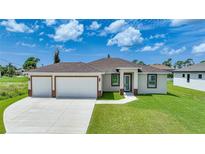 Newly built home with a two-car garage and well-manicured lawn at 16 Tee View Rd, Rotonda West, FL 33947