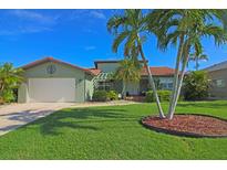 Single-story home with attached garage and palm trees at 2160 Aqui Esta Dr, Punta Gorda, FL 33950