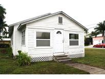 White house with front yard, steps, and small plants at 702 W Olympia Ave, Punta Gorda, FL 33950