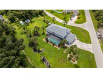 Expansive aerial view of a two-story home featuring a backyard pool, mature trees, and a large, well-manicured lawn at 196 Lecturn St, Port Charlotte, FL 33954