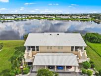 Aerial view of condo with lake view, two-car garage, and community at 26283 Nadir Rd # 201, Punta Gorda, FL 33983