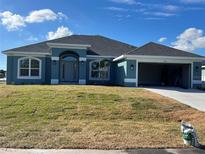 Newly constructed home with a two-car garage and well-manicured lawn at 10133 Audrey St, Port Charlotte, FL 33981