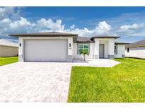 Modern single-story home with gray siding and a two-car garage at 2743 Hopwood Rd, North Port, FL 34287