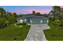 Charming single-story home featuring a three-car garage and well-manicured lawn at 14516 San Domingo Blvd, Port Charlotte, FL 33981