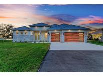 Modern home exterior with a metal roof and wood garage doors at 6100 Riverside Dr, Punta Gorda, FL 33982