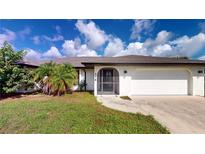 White single-story house with a two-car garage and landscaped front yard at 176 N Waterway Nw Dr, Port Charlotte, FL 33952